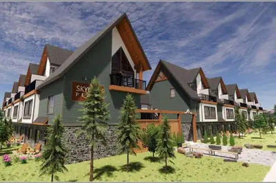 a large house on top of a grass field at Mountain View Studio in Town in Canmore