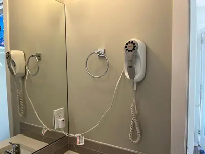 a bathroom with a blow dryer on the wall at Mountain View Studio in Town in Canmore