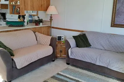 a living room with two chairs and a couch at 4 Seasons Lakeview Cottage w/ Private Boating Dock in Westerose