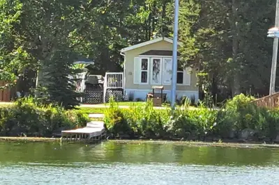 a cottage on the shore of a lake at 4 Seasons Lakeview Cottage w/ Private Boating Dock in Westerose