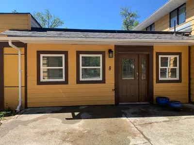 a yellow house with a door and two windows at Country studio pet friendly in Port Alberni