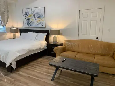 a bedroom with a bed and a couch and a coffee table at Country studio pet friendly in Port Alberni