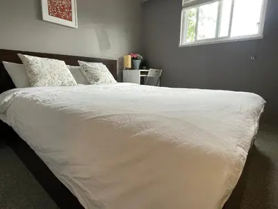a bed with white sheets and pillows in a bedroom at private room with queen bed in richmond 202 in Richmond