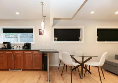 a kitchen with a glass table and white chairs at Lovely 1 Bedroom Suite Near Town in Victoria