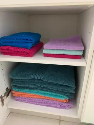 a group of towels are stacked on a shelf at Cozy Basement Suite close to Downtown,Edmonton in Edmonton
