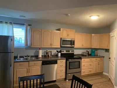a kitchen with wooden cabinets and stainless steel appliances at Cozy Basement Suite close to Downtown,Edmonton in Edmonton
