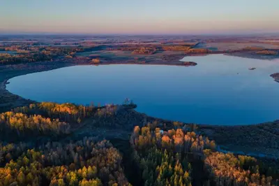 an aerial view of a lake in a forest at Refuge Bay's Ignis Dome - Luxury Off Grid Escape in Cherhill