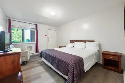 a bedroom with a large bed and a television at Grantview Inn in Surrey
