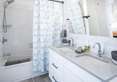 a bathroom with two sinks and a shower curtain at Mountain Dreams - Revelstoke Home Near RMR in Revelstoke