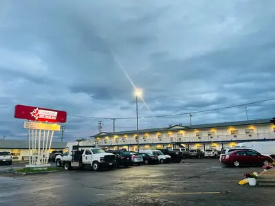 a parking lot with cars parked in front of a building at Canadas Best Value Inn Fort St John in Fort Saint John