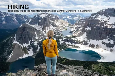 a woman standing on top of a mountain overlooking a lake at LUXURY Downtown Sunset Getaway - Your Home Away From Home - Fully Stocked Kitchen, Gym, Balcony, FREE PARKING in Calgary