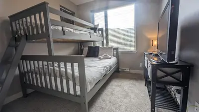 a bedroom with a bunk bed with a ladder at Echo Landing #37 condo in Sun Peaks
