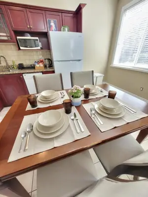 a dining room table with white plates and silverware at Moonlight Suite in Vancouver