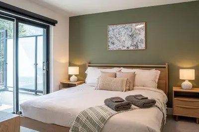a bedroom with a bed with two towels on it at Revy Bliss - Dazzling Condo in the Mountains in Revelstoke