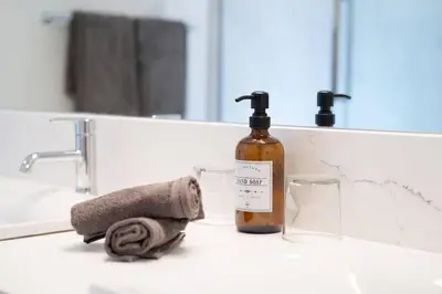 a bathroom sink with a bottle of soap and a towel at Revy Bliss - Dazzling Condo in the Mountains in Revelstoke
