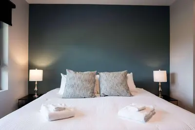 a bedroom with a large white bed with towels on it at Northern Exposure by Revelstoke Vacations in Revelstoke