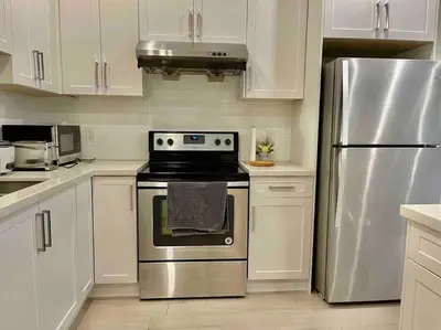 a kitchen with a stainless steel stove and refrigerator at \u6e29\u897f\u6c11\u5bbf Vancouver West Quiet Home in Vancouver