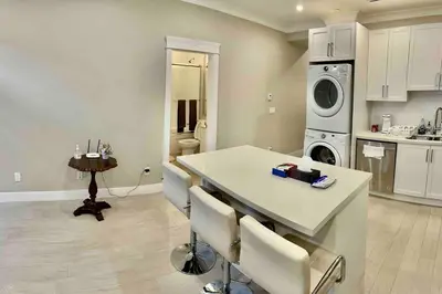 a kitchen with a table and a washing machine at \u6e29\u897f\u6c11\u5bbf Vancouver West Quiet Home in Vancouver