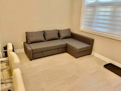 a couch in a living room with a window at \u6e29\u897f\u6c11\u5bbf Vancouver West Quiet Home in Vancouver