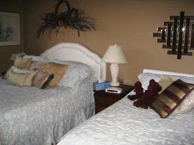 a bedroom with two beds and a teddy bear on a night stand at McDougall Lane Bed & Breakfast in Drumheller