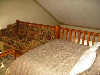 a bedroom with a bed and a couch at McDougall Lane Bed & Breakfast in Drumheller