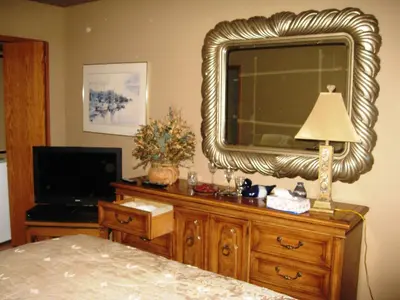 a bedroom with a large mirror on a dresser with a lamp at McDougall Lane Bed & Breakfast in Drumheller