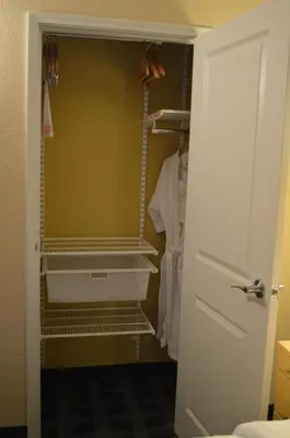 a walk in closet with a white shirt on a rack at TownePlace Suites by Marriott Red Deer in Red Deer