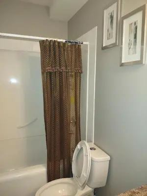 a bathroom with a toilet and a shower and a tub at Spacious One Bedroom Walkout Basement Suite in Calgary