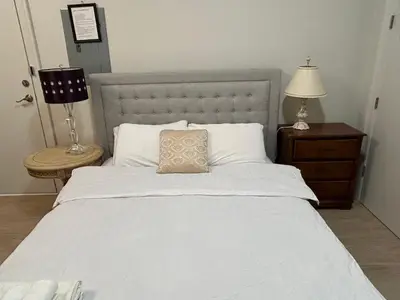 a bedroom with a white bed with a pillow on it at Rose Garden Vacation Studio in Richmond
