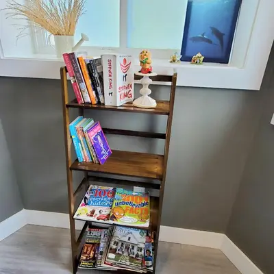 a book shelf filled with books and magazines at Garden House Near Heritage Park-Coliseum -HWY 1-Fishing-Cultus Lake in Chilliwack