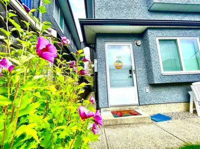 a house with a door and flowers in front of it at Charming 1BR near Metrotown DT Burnaby/ Vancouver in Vancouver