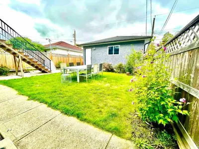 a garden with a table and chairs in the yard at Charming 1BR near Metrotown DT Burnaby/ Vancouver in Vancouver