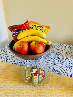 a bowl of fruit with apples and bananas on a table at Garden home in Victoria in Victoria