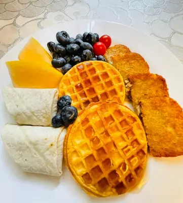 a plate of breakfast food with waffles and other foods at Garden home in Victoria in Victoria