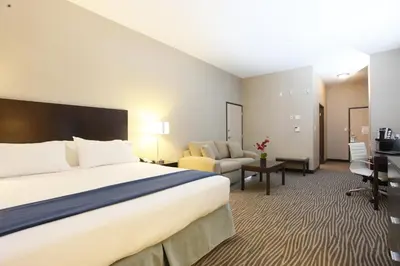 a hotel room with a large bed and a desk at Holiday Inn Express Fort St John by IHG in Fort Saint John