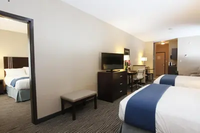 a hotel room with two beds and a mirror at Holiday Inn Express Fort St John by IHG in Fort Saint John