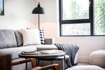 a living room with a couch and a table at The Shred Shack - Stylish Revelstoke Condo in Revelstoke