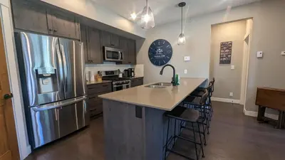 a kitchen with a stainless steel refrigerator and a counter at Echo Landing #13 condo in Sun Peaks