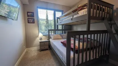 a bedroom with a bunk bed next to a window at Echo Landing #13 condo in Sun Peaks