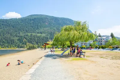 a group of people sitting on a beach at Wanderlust Studio Suite with Private Patio in Harrison Hot Springs