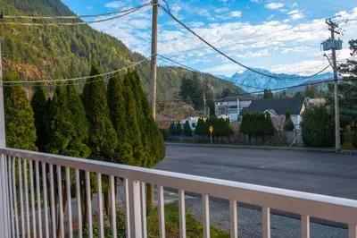 a balcony with a view of a street and a mountain at Wanderlust Studio Suite with Private Patio in Harrison Hot Springs