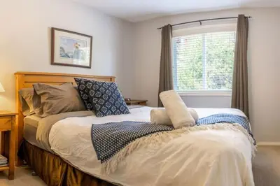 a bedroom with a large bed with a window at Trailblazers Retreat 3 Bed with Family Games Room in Big White