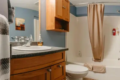 a bathroom with a sink and a toilet and a tub at Trailblazers Retreat 3 Bed with Family Games Room in Big White