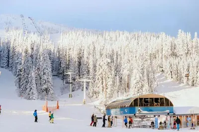 a group of people on a ski slope with a ski lift at Trailblazers Retreat 3 Bed with Family Games Room in Big White