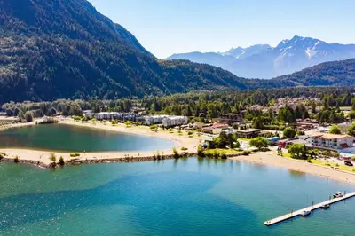 an aerial view of a beach with mountains in the background at Lake Time Harrison in Harrison Hot Springs