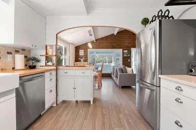 a kitchen with white cabinets and an archway at Lake Time Harrison in Harrison Hot Springs