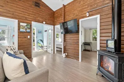 a living room with a fireplace and a tv at Lake Time Harrison in Harrison Hot Springs