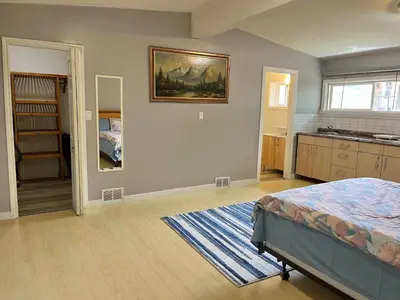 a bedroom with a bed and a painting on the wall at Whole Suite to Yourself at Coquitlam Centre! in Port Coquitlam