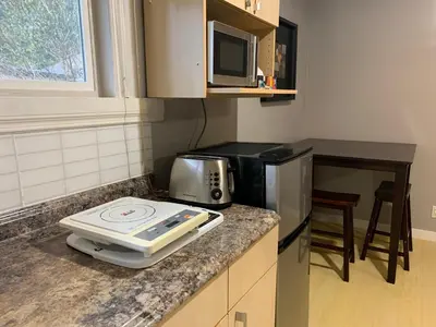 a kitchen with a counter with a microwave and a stove at Whole Suite to Yourself at Coquitlam Centre! in Port Coquitlam