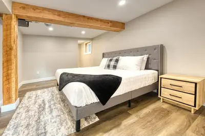 a bedroom with a large bed and a wooden dresser at Backyard Oasis Hot Tub, BBQ, Outdoor Bar in Invermere